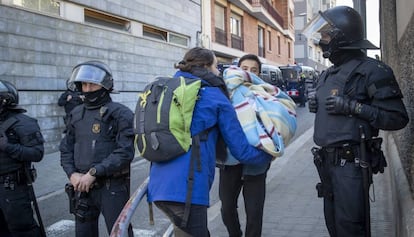 Una mujer recoge unas mantas tras ser desahuciada por los Mossos