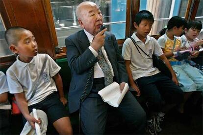 Tatsuo Sora, un superviviente de 77 años, cuenta su experiencia a un grupo de niños desde uno de los tranvías que sobrevivieron a la bomba en Hiroshima.
