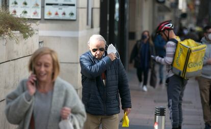 Un hombre se quita la mascarilla en una calle de Madrid, este jueves.