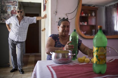 Delfina Ramírez, junto a su marido José, bebe agua de botellas congeladas en su chabola, en el asentamiento de El Vacie (Sevilla).