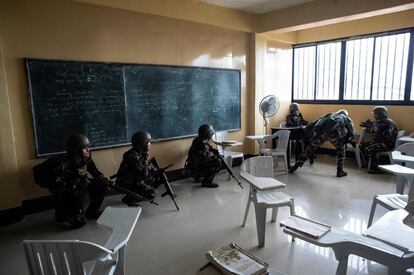 Militares del ejército filipino se agachan en un aula durante una misión contra francotiradores islamistas en Marawi (Filipinas).