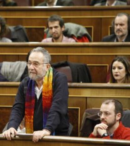 Pedro Agudo, diputado de Podemos, con camisa, jersey y bufanda de colores. A su lado, Jorge Luis Bail.