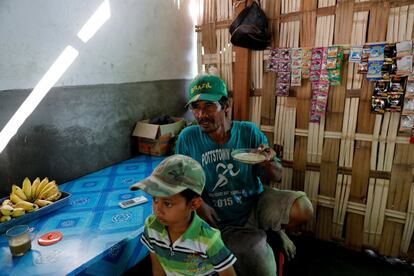 Salam, de 54 años, afirma que la basura reciclada pagó la educación de sus hijos y también compró una casa para su familia y su ganado."Tengo nueve cabras ahora", dice Salam, quien trabaja como agente de residuos entre los aldeanos y una fábrica de papel cercana y dice que su trabajo es más fácil que la agricultura. En la imagen, Salam bebe café dentro de un puesto con su nieto Rayhan Fastabichul Khoirot, antes de comenzar a trabajar en la aldea de Bangun en Mojokerto, provincia de Java Oriental, Indonesia.