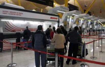 Un grupo de viajeros espera en los mostradores de Iberia del aeropuerto de Madrid-Barajas. EFE/Archivo