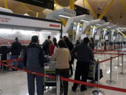 Un grupo de viajeros espera en los mostradores de Iberia del aeropuerto de Madrid-Barajas. EFE/Archivo