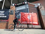 A man cycles past banners outside of Anfield Stadium, Liverpool, England protesting against the clubs decision to join the European Super Leaguer, Tuesday April 20, 2021. Chelsea and Manchester City are preparing to dramatically abandon plans to join a breakaway Super League threatening to implode the project by a group of elite English, Spanish and Italian clubs less than two days after it was announced.  (Peter Byrne/PA via AP)