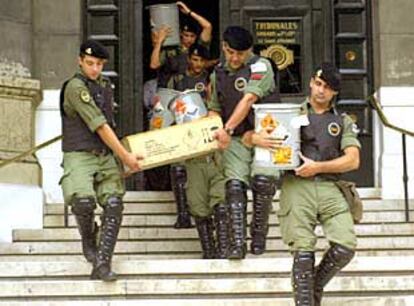 Policías argentinos trasladan botes de gas lacrimógeno en la entrada del Tribunal Supremo.