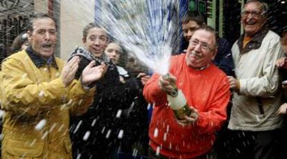 El propietario de una administración de Getafe celebra con cava el segundo y quinto premios.