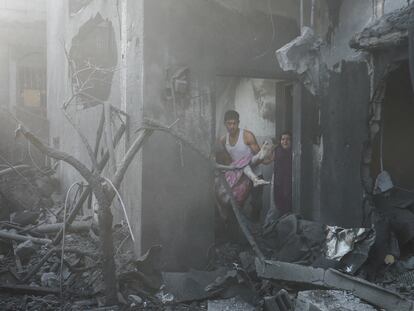 Un hombre carga con una niña palestina herida por un bombardeo israelí sobre Gaza este miércoles.
