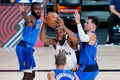 Luka Doncic intenta frenar a Kawhi Leonard.