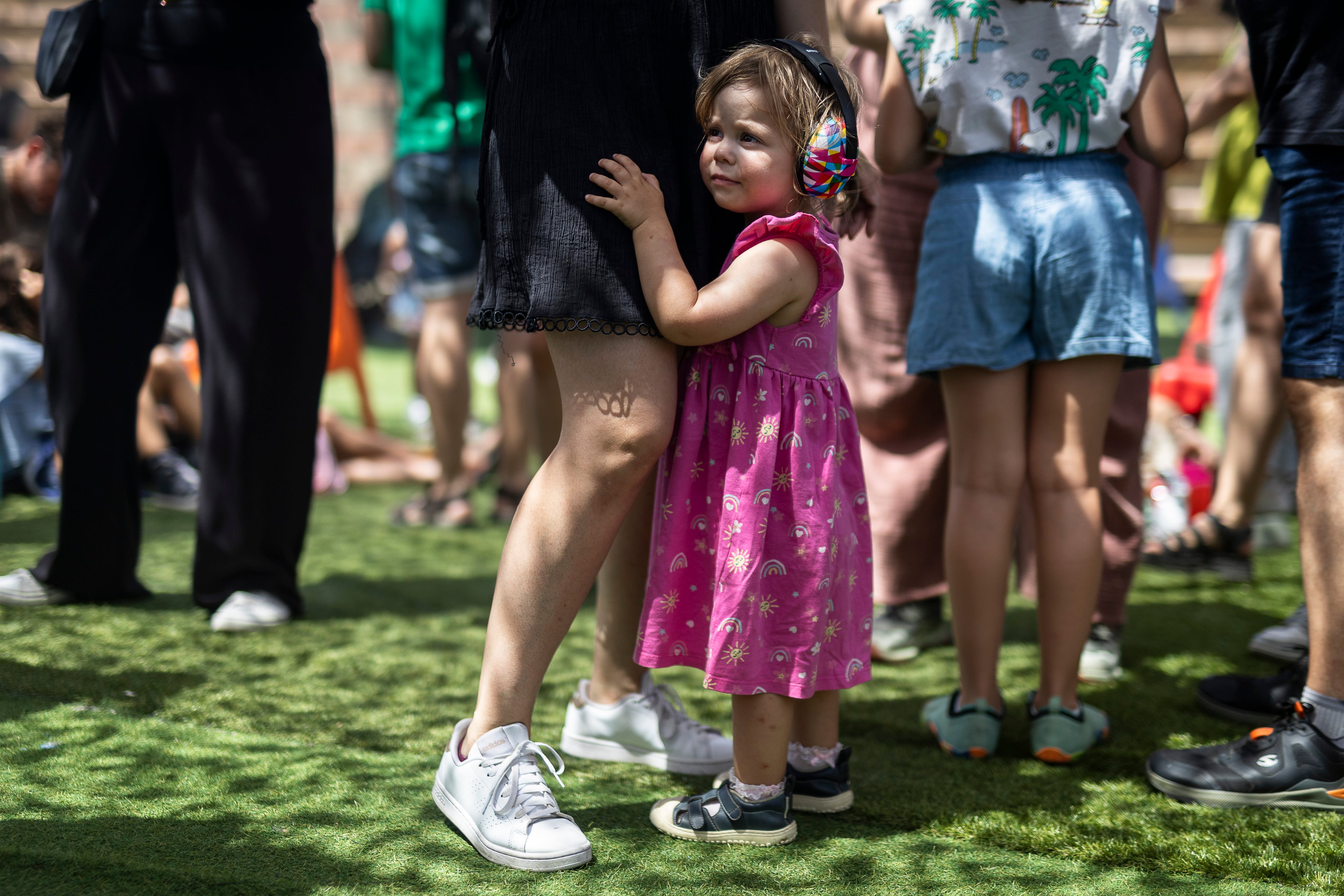 Una niña escucha música en el Sónar Kids agarrada de su madre, este sábado.