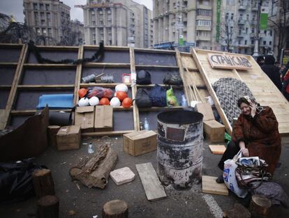 Una mujer habla por un teléfono junto a una de las barricadas situadas en la plaza de la Independencia en Kiev (Ucrania), 5 de diciembre de 2013.