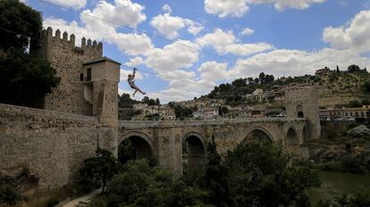 Una chica se tira con una tirolina por encima del río Tajo en Toledo.