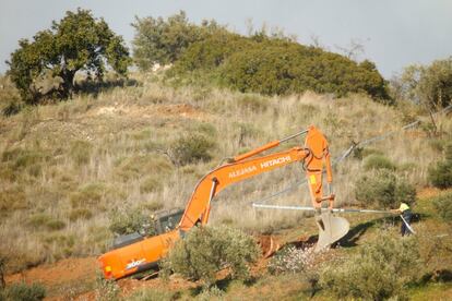 Un operario trabaja con una retroexcavadora en la preparación del terreno en una zona cercana al pozo donde cayó el pequeño Julen.