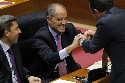 Un diputado del PP saluda a Francisco Camps durante el pleno, ante Vicente Rambla.