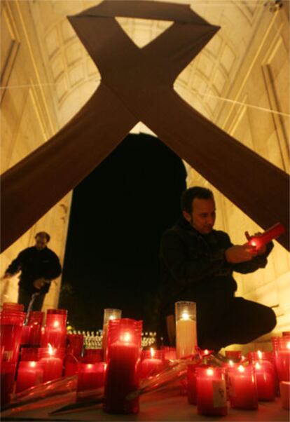 Velas y un gran lazo en la Puerta de Alcalá de Madrid recuerdan a las víctimas del sida.