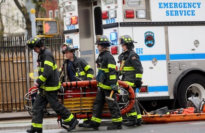 Cuatro bomberos cerca de la estación donde se ha producido el suceso, en Brooklyn. De los 10 heridos por impacto de bala, 5 están en estado crítico, pero estable.
