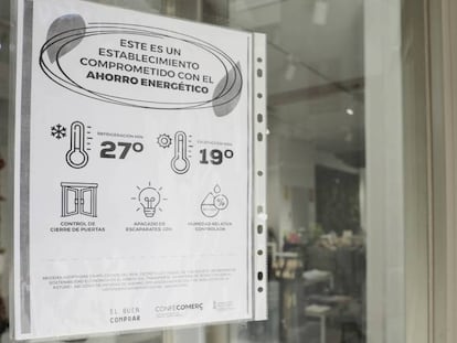 Un cartel informativo en una tienda de ropa de Valencia sobre las medidas del plan de ahorro energético.