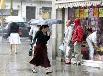 Imagen de los viandantes resguardándose de la lluvia en el centro de Barcelona.