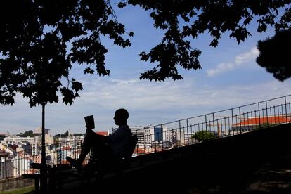 Un hombre lee en el jardín del Torel (Lisboa).