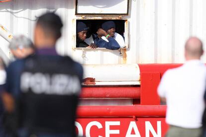 Dos migrantes miran por la ventana del barco de rescate Ocean Viking al llegar al puerto italiano de Messina, el martes.