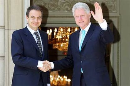 Bill Clinton saluda desde la entrada del palacio de la Moncloa, junto a José Luis Rodríguez Zapatero.