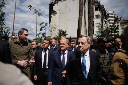 El Kiev que este jueves ha recibido a tres de los hombres más poderosos de Europa se parece muy poco a lo que uno podría imaginarse como un país en guerra. Al margen de alguna que otra sirena, sacos terreros frente a escasos edificios y un toque de queda que recuerda que algo excepcional está ocurriendo, algunos habitantes de la capital de Ucrania parecen entregados a los placeres del verano en terrazas repletas o paseos con helados. En la imagen, Macron, Scholz y Draghi, acompañados de varios representantes del Gobierno de Ucrania, durante su visita a la ciudad de Irpin.