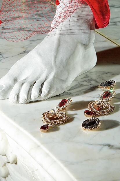 Tocado con redecilla de Mibúh (125 €), pendiente chapados en oro de Dolce & Gabbana (c. p. v.), pendiente negro de H&M (9,99 €) y pie de cemento de Zara Home (29,99 €).