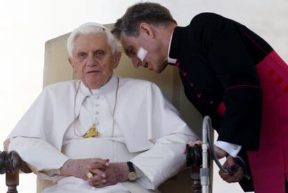 El Papa escucha a su secretario personal, Georg Gaenswein, en el Vaticano.