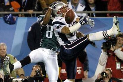 Rodney Harrison (a la derecha), de los Patriots, pierde el balón ante la acometida de Terrell Owens, de los Eagles.