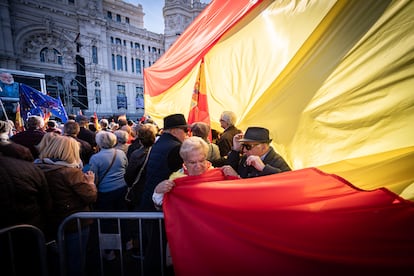 Una mujer sujeta parte de una bandera gigante de España durante la protesta celebrada en Madrid, este sábado. 