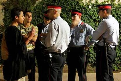 Agentes de los Mossos d'Esquadra conversan con unos ciudadanos en su primer día de despliegue en Barcelona.