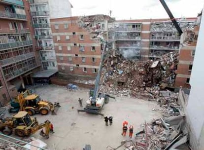 Las máquinas trabajan en las tareas de desescombro en el edificio del número 4 de la calle de Gaspar Arroyo de Palencia, que ayer se vino abajo por una explosión de gas.