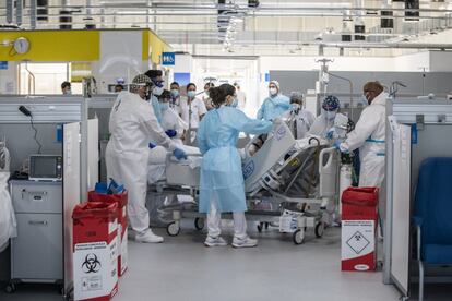 Un equipo de sanitarios traslada a una paciente a la zona de semicríticos después de realizarle varias pruebas.