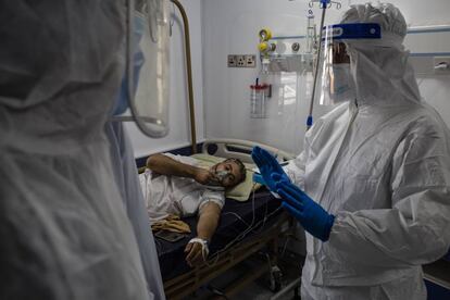 Doctores atienden a un paciente por coronavirus en un hospital en Najaf (Irak). El país ha registrado 5.036 nuevos casos en el último día, según ha informado este viernes el Ministerio de Salud, la cifra más alta desde el inicio de la pandemia.