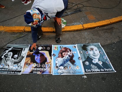 Un hombre coloca insignias con la imagen de Cristina Fernández sobre carteles afuera de la casa de la vicepresidenta, el 2 de septiembre de 2022, en Buenos Aires.
