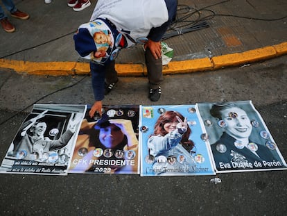 Un hombre coloca insignias con la imagen de Cristina Fernández sobre carteles afuera de la casa de la vicepresidenta, el 2 de septiembre de 2022, en Buenos Aires.