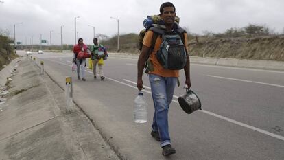 Um venezuelano caminha rumo a Lima pela Rodovia Pan-Americana, neste domingo.