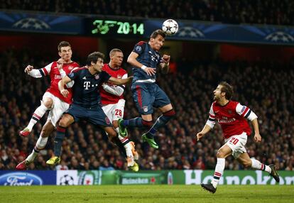 Mario Mandzukic y Javi Martinez, de Bayern, saltan a por el balón frente a Laurent Koscielny, Kieran Gibbs y  Mathieu Flamini del Arsenal. 