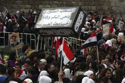Manifestantes sirios portan un falso ataúd con el mensaje en árabe "El pueblo sirio llora la muerte de la Liga Árabe".