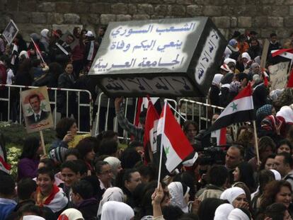 Manifestantes sirios portan un falso ataúd con el mensaje en árabe "El pueblo sirio llora la muerte de la Liga Árabe".
