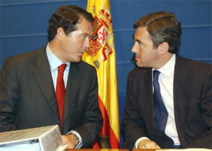 José María Michavila, izquierda, conversa con Ángel Acebes, durante la rueda de prensa para informar de la entrada en vigor de los juicios rápidos.