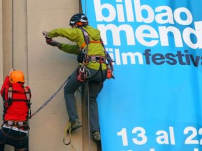 Los escaladores ascienden por el edificio de Turismo de la plaza Circular para colgar una hamaca. 