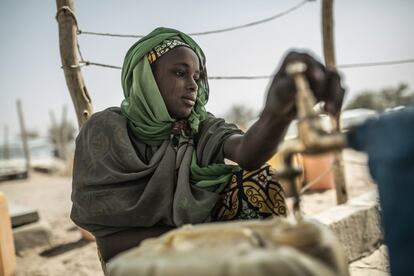 Una chica recoge agua en el campo de refugiados de Sayan.