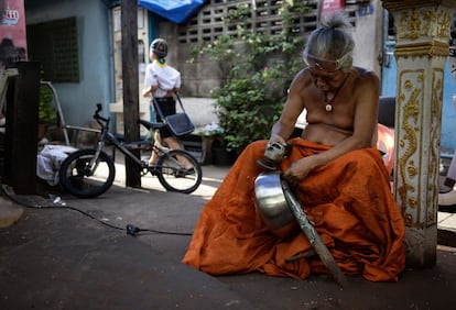 Un hombre puliendo el acero de uno de los cuencos de limosnas tradicionales budistas utilizados para la festividad del 'Khao Pansa' en Bangkok, Tailandia.