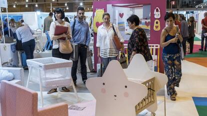 Un grupo de visitantes ve diferentes productos para bebé en la feria de Puericultura Madrid 2017.