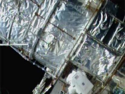 Dos astronautas trabajan en la reparación del telescopio <i>Hubble</i> en 1997.