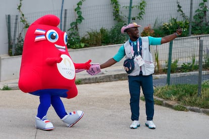 La mascota de los juegos Phryge Olímpica posa con un atleta por el centro de París, este viernes. 