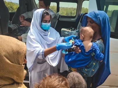 Akeela, orientadora de salud de Médicos Sin Fronteras, atiende a un bebé durante las inundaciones de Pakistán.