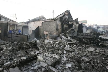Un grupo de hombres entre las casas destruidas en la isla de Yeonpyeong, en Corea del Sur.